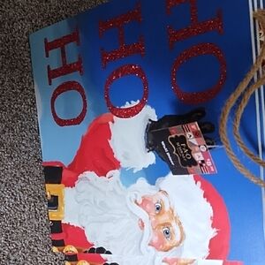 FAO Schwarz branded Santa Claus wall décor sign featuring glittery "Ho Ho Ho"